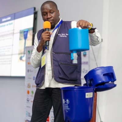 Michael Kokonya demonstrating chlorine dispenser equipment